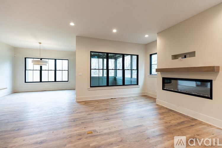 A spacious living room with hardwood floors and large windows.