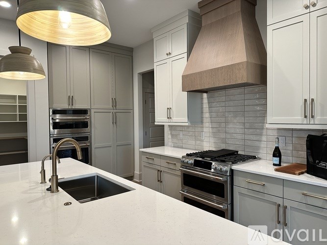 A modern kitchen with a sink, stove, and oven.