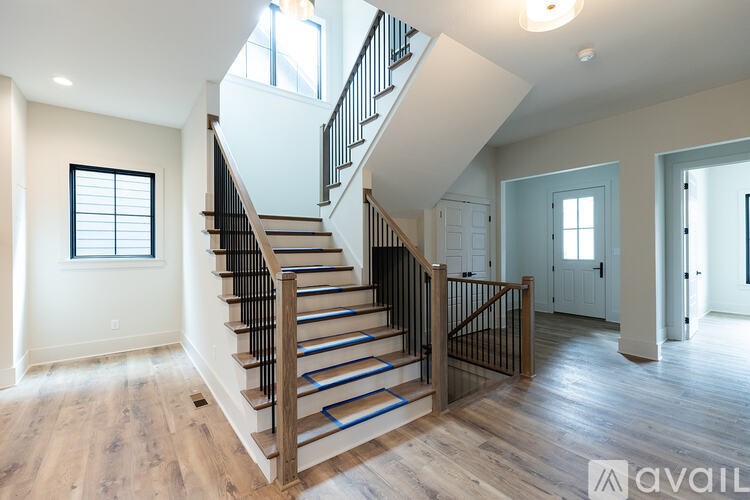 A wooden staircase with a metal railing leads up to a second floor.