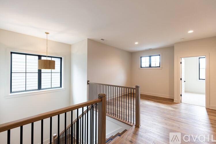 A room with a wooden staircase and a window with blinds.