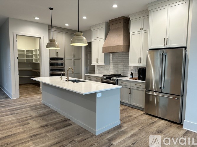 A modern kitchen with a large island and stainless steel appliances.