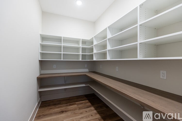 A room with a lot of shelves and a wooden floor.