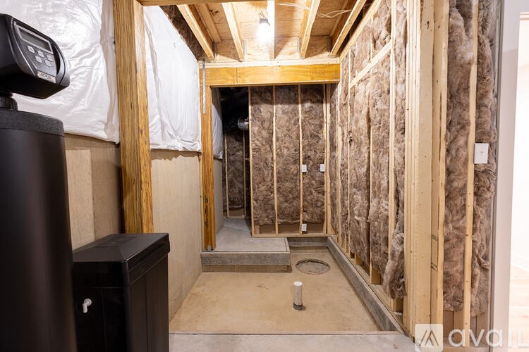 A room under construction with insulation on the walls and a concrete floor.