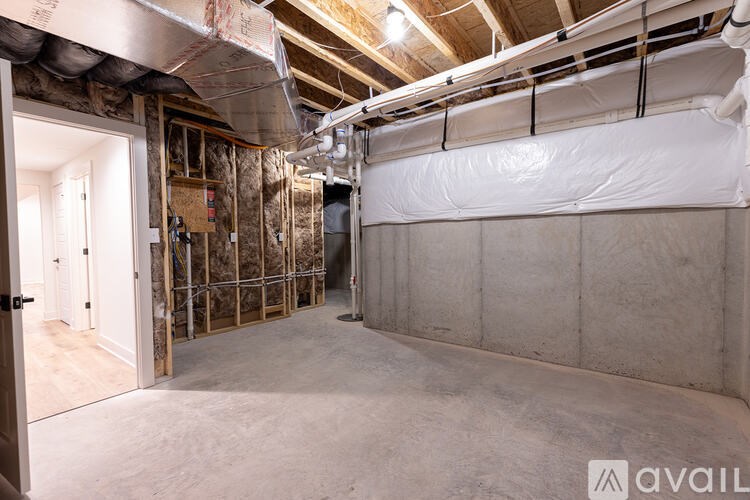A room under construction with exposed ceiling and walls.