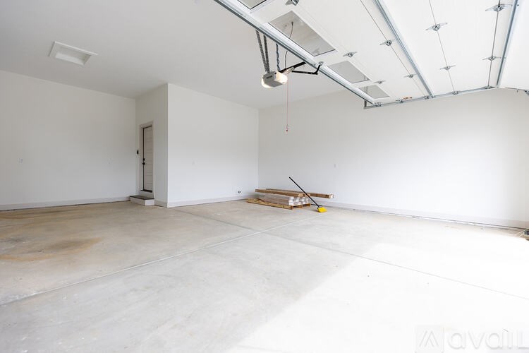 A large empty room with a concrete floor and white walls.