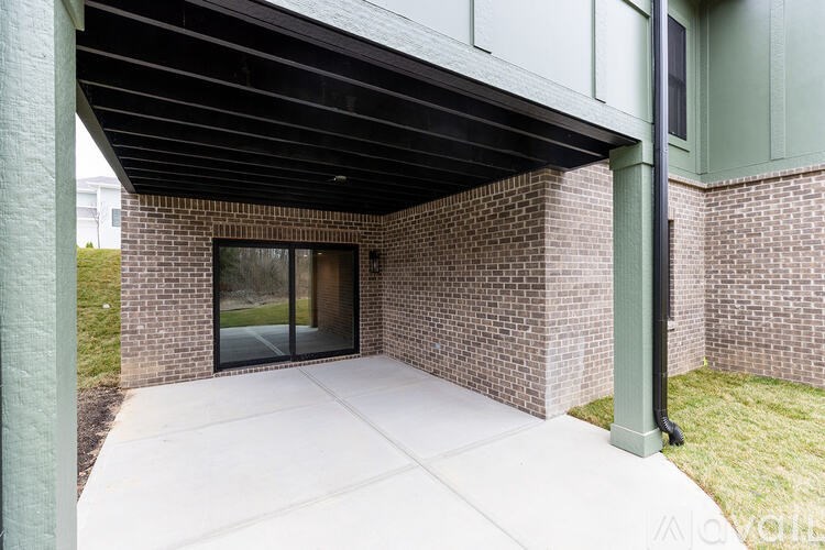 A modern house with a glass door and a covered walkway.