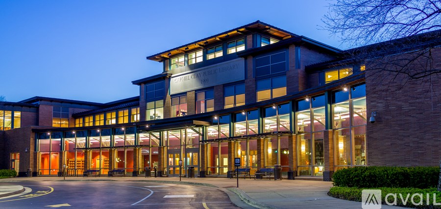 A modern building with a glass facade and a circular driveway in front.