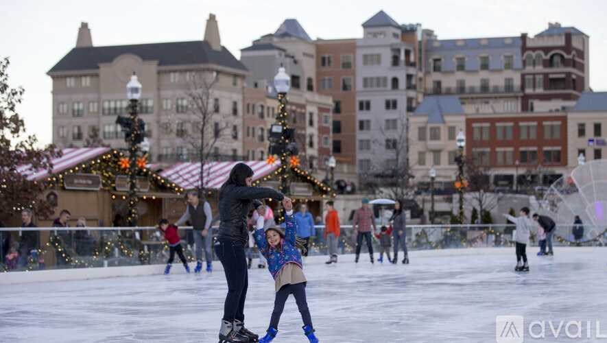 A woman and a child are ice skating on an outdoor rink.