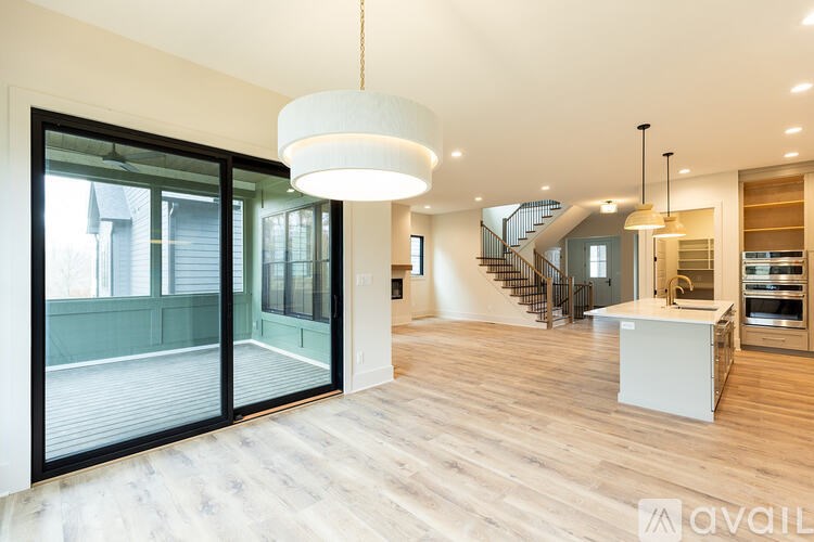 A modern kitchen with a white island and pendant lighting.