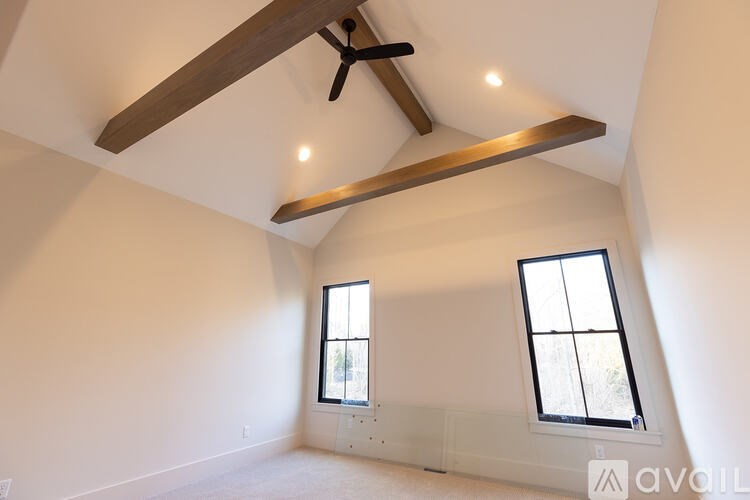 A room with a window and a fan on the ceiling.