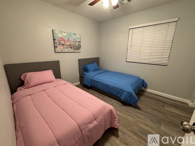A bedroom with a pink bed and a blue bed.
