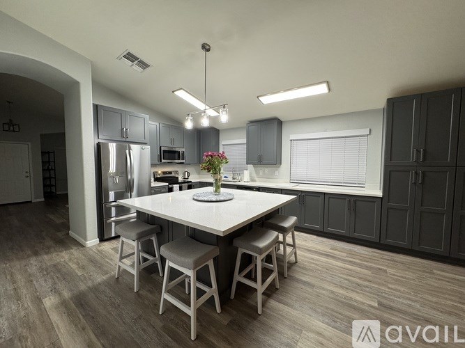 A modern kitchen with a large island and bar stools.