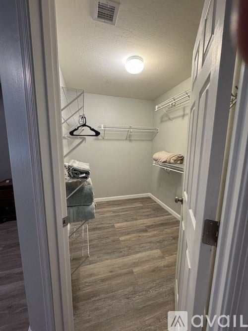 A hallway with a hanger on the wall and a towel hanging on the rack.