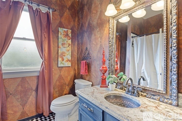 A bathroom with a toilet, sink, and a mirror.