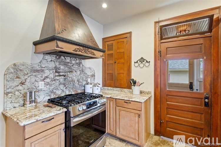 A kitchen with a stone backsplash and wooden cabinets.