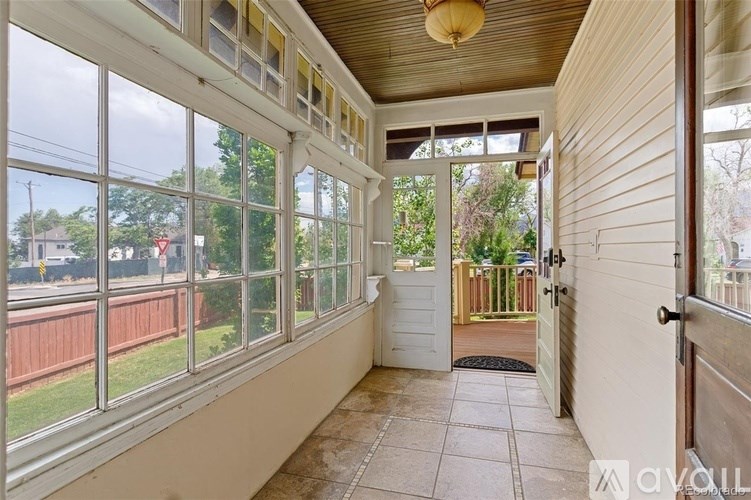 A sunny day in a room with a view of the street through the windows.