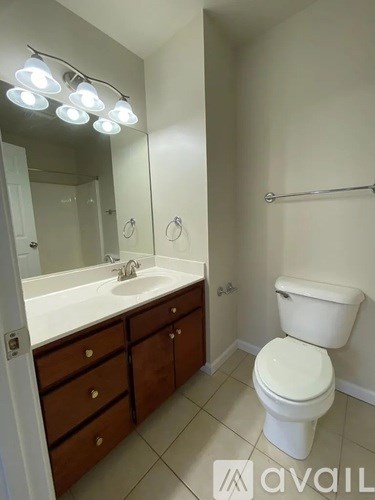 A bathroom with a toilet, sink, and mirror.