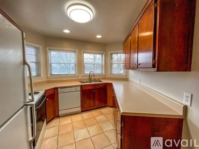 A kitchen with brown cabinets and a white refrigerator.