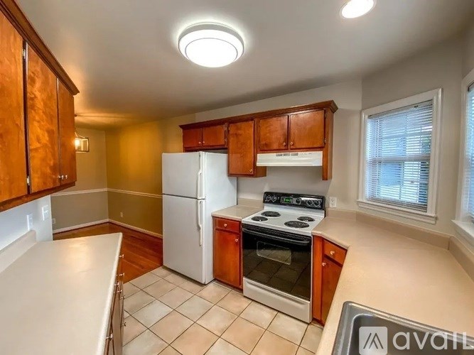 A kitchen with a white refrigerator and a white stove top oven.