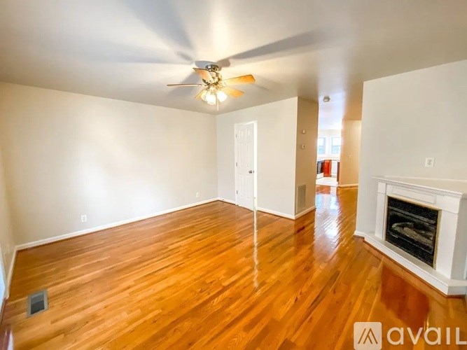 A room with a fireplace and a ceiling fan.