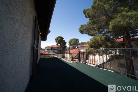 A view from a balcony looking out at a tennis court and trees.
