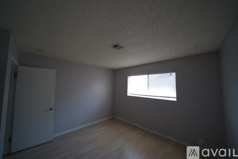 A room with a window and wooden flooring.