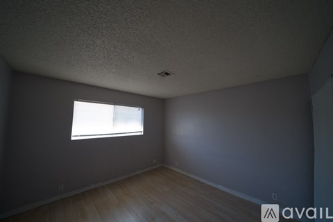 A room with a window and wooden floors.