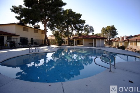A pool surrounded by trees and buildings.