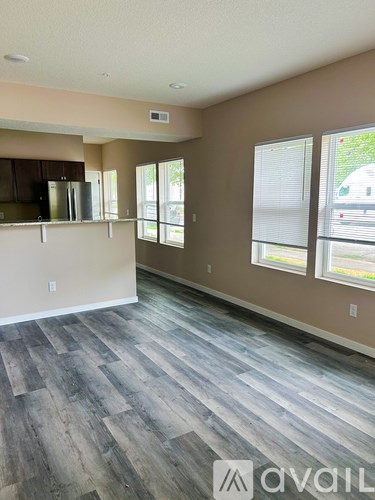 A room with wooden flooring and a window with blinds.