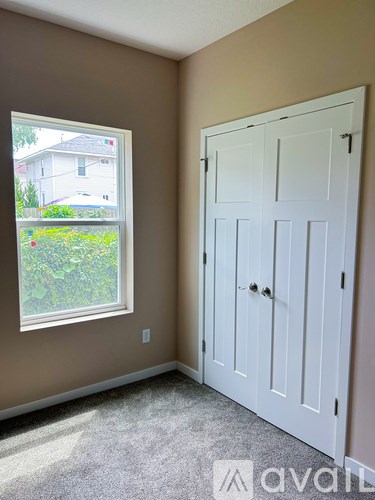 A white door is in a room with a window.