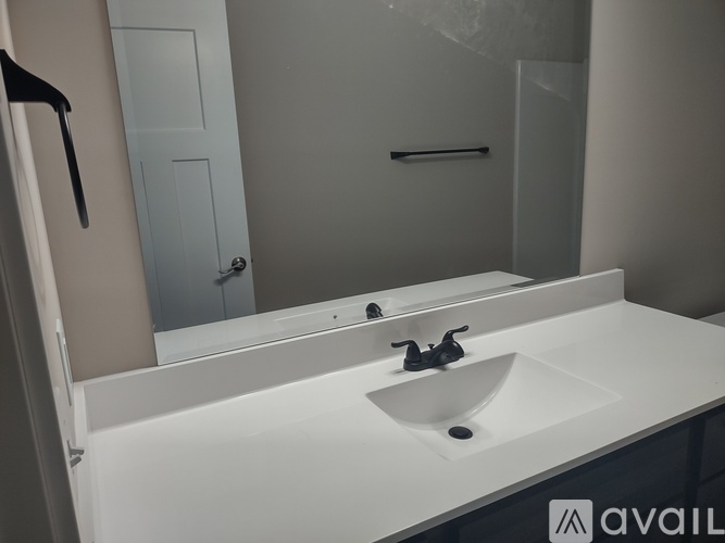 A bathroom with a toilet, sink, and mirror.