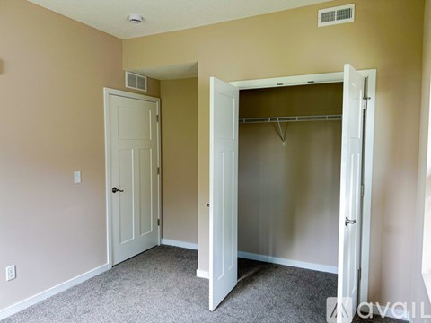 A room with a white door and a closet with a white door.