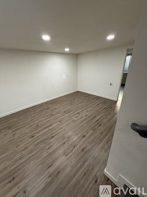 A room with wooden flooring and white walls.