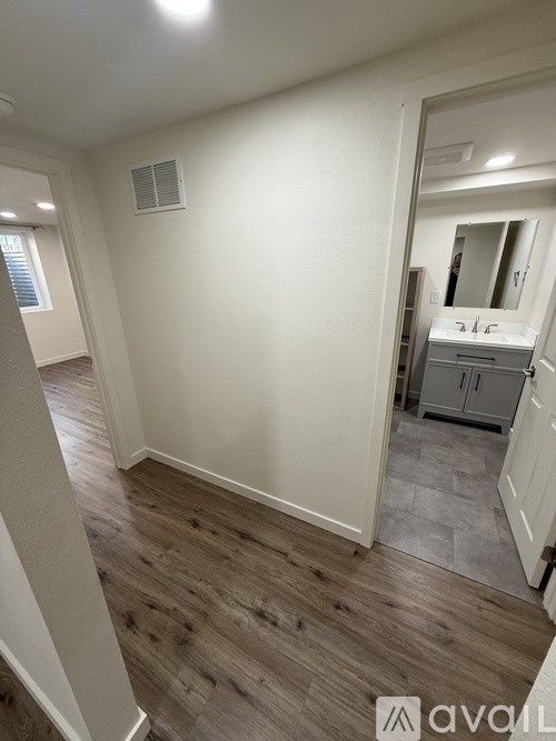 A room with wooden flooring and a mirror on the wall.