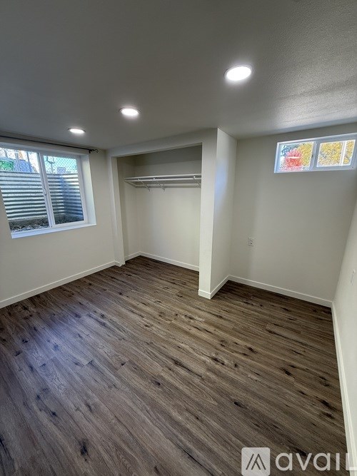 A room with wooden flooring and white walls.