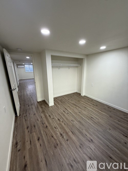 A room with wooden flooring and white walls is available for rent.