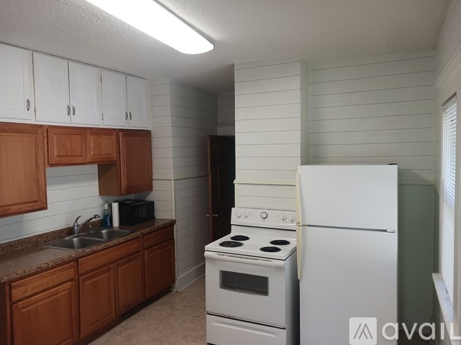 A kitchen with white appliances and wooden cabinets.