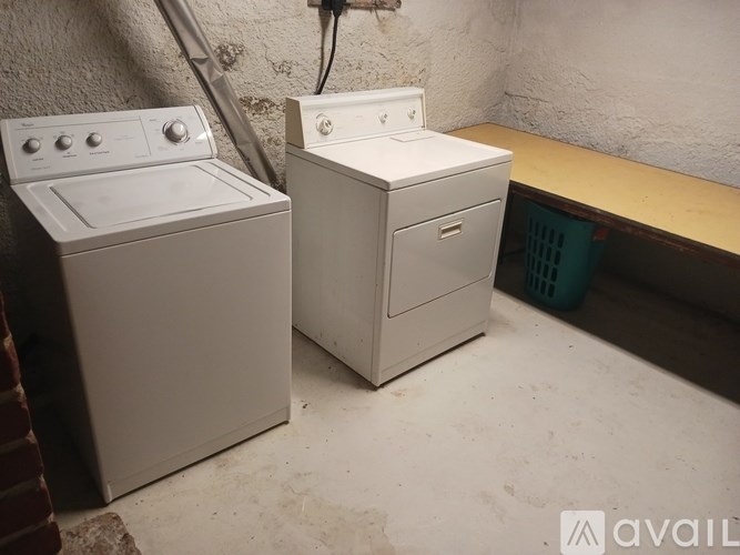 Two white appliances, a washing machine and a dryer, are placed in a room.