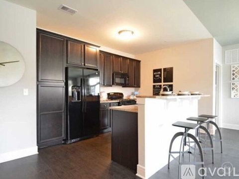 A kitchen with dark brown cabinets and a white island.