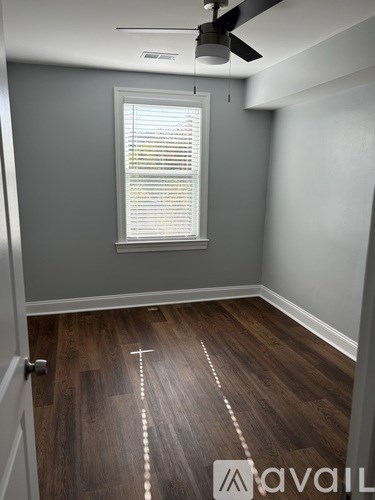 A room with wooden flooring and a ceiling fan.