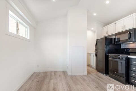 A kitchen with a black stove top oven and a white wall.