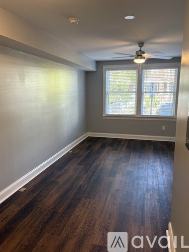 A room with wooden floors and a ceiling fan.
