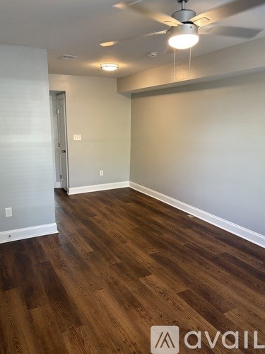 A room with wooden flooring and a ceiling fan.