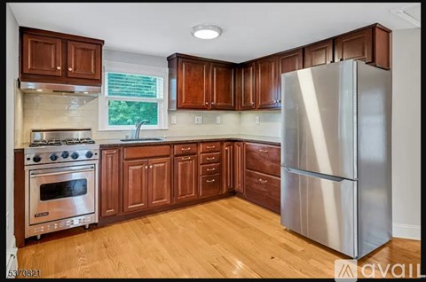 A kitchen with wooden cabinets and a stainless steel refrigerator.