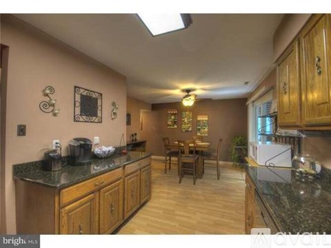 A kitchen with wooden cabinets and a granite countertop.