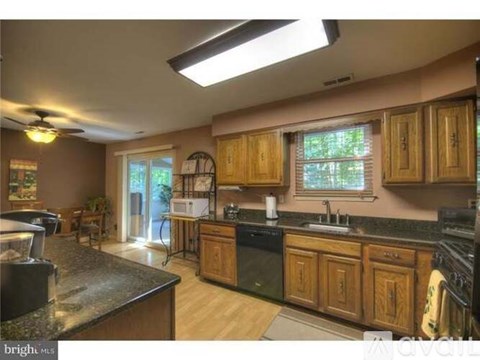 A kitchen with wooden cabinets and black appliances.