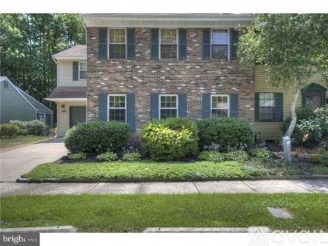 A house with a green lawn in front.
