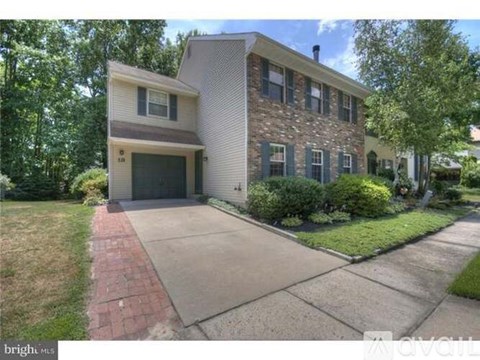 A two-story house with a garage and a driveway.