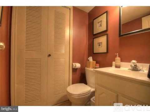 A bathroom with a toilet, sink, and mirror.