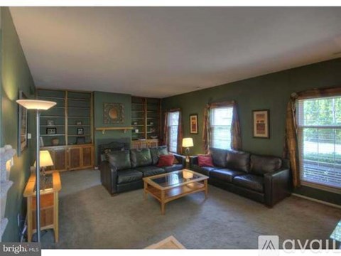 A living room with a couch, coffee table, and a lamp.